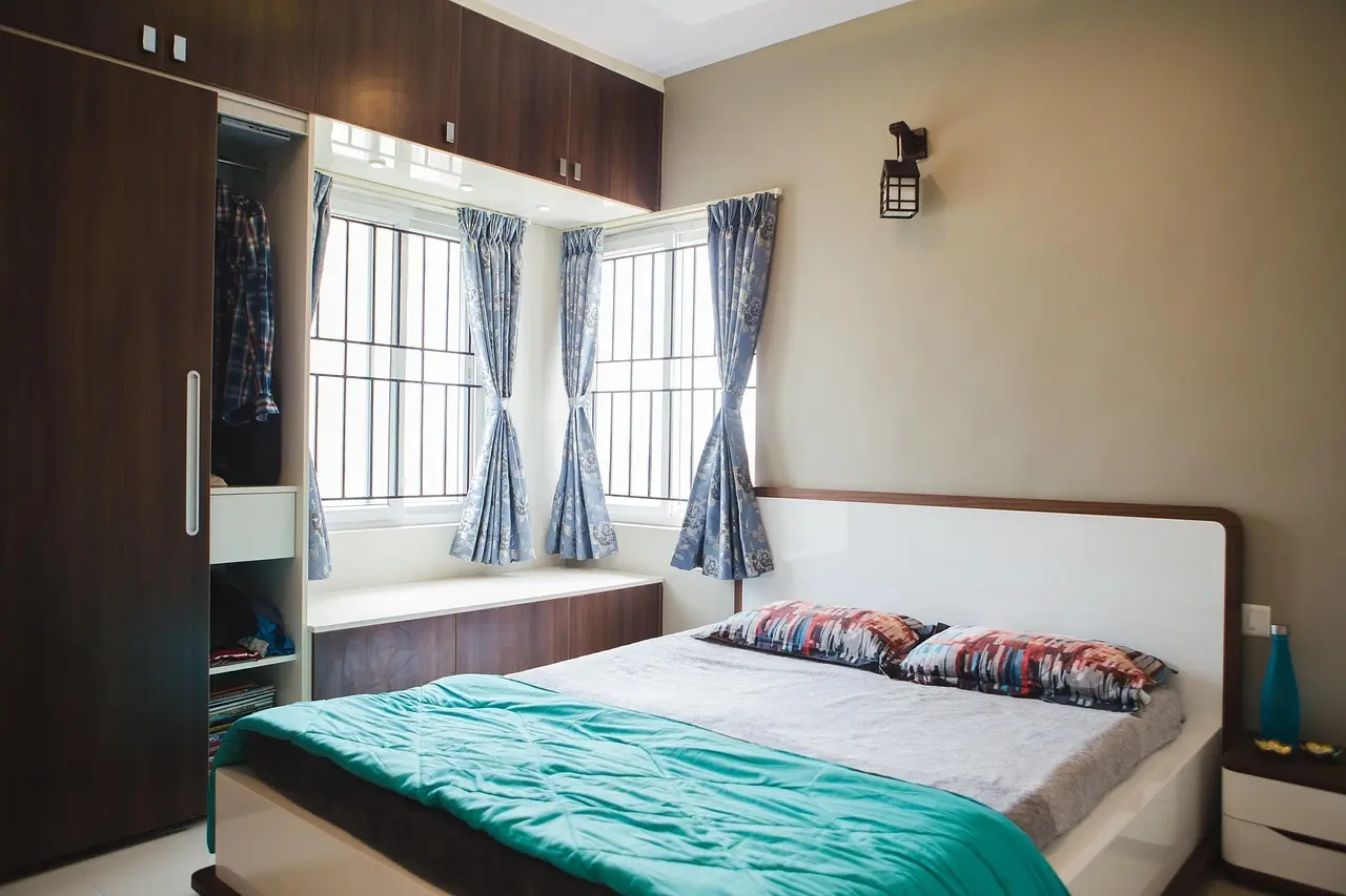 Ryddeligt soveværelse med garderobe og gardiner